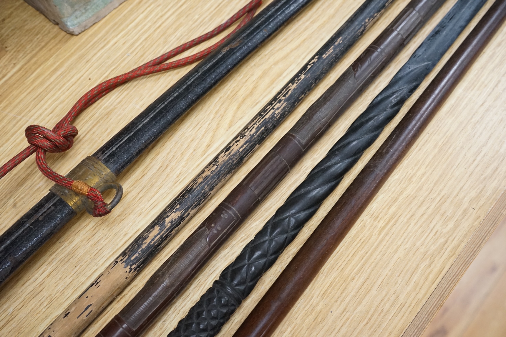 An officer’s sword, three walking sticks and an antique sword stick, longest walking stick 92cm long
